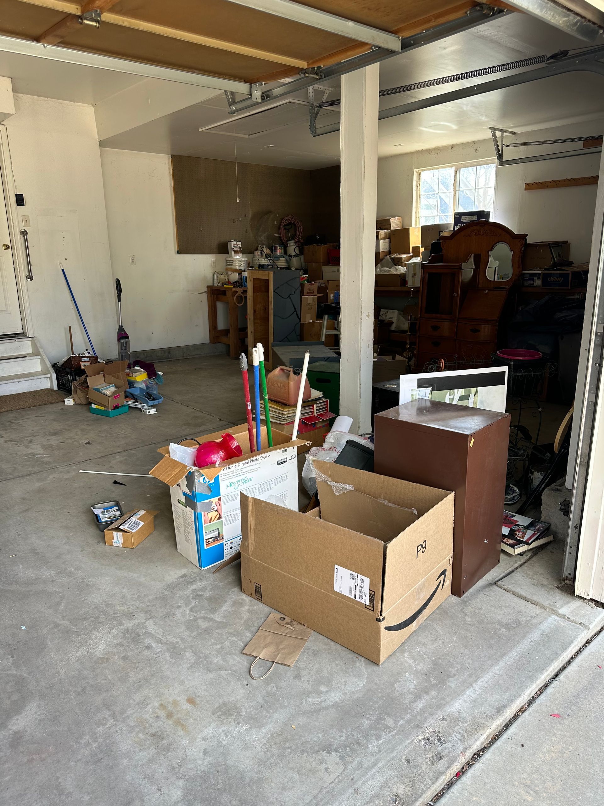 A garage filled with lots of boxes and furniture.