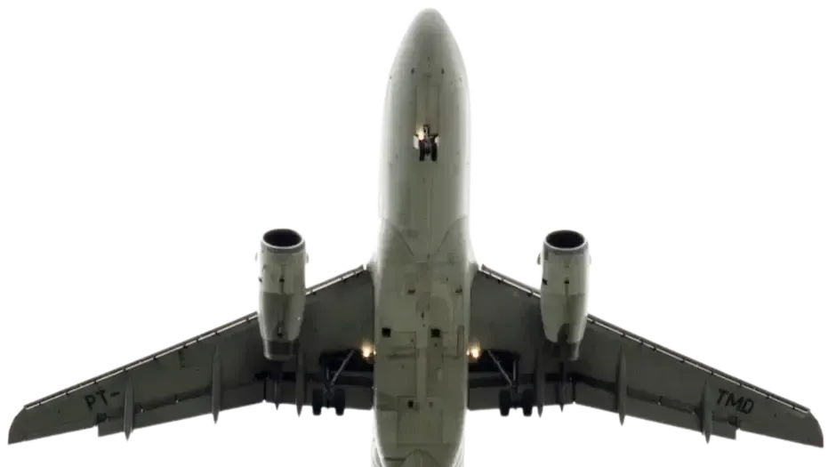 Airplane from below, white body, wings extended, landing gear visible, against overcast sky.