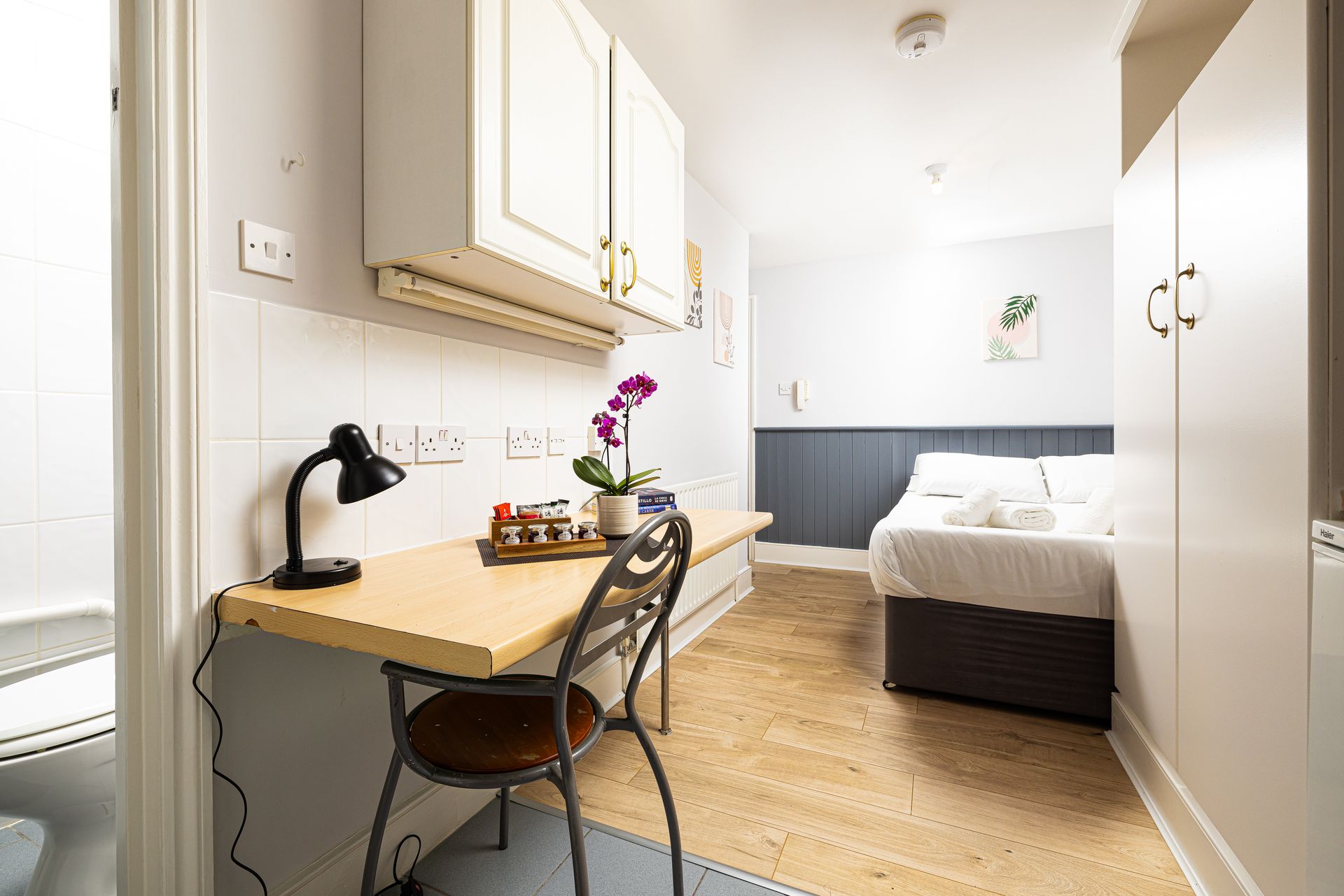 Bright minimalist bedroom with desk, chair, bed, and wardrobe in neutral tones