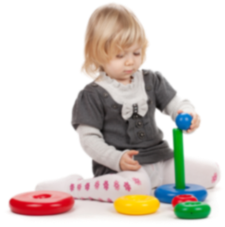 A toddler playing with a colorful stacking ring toy against a white background.