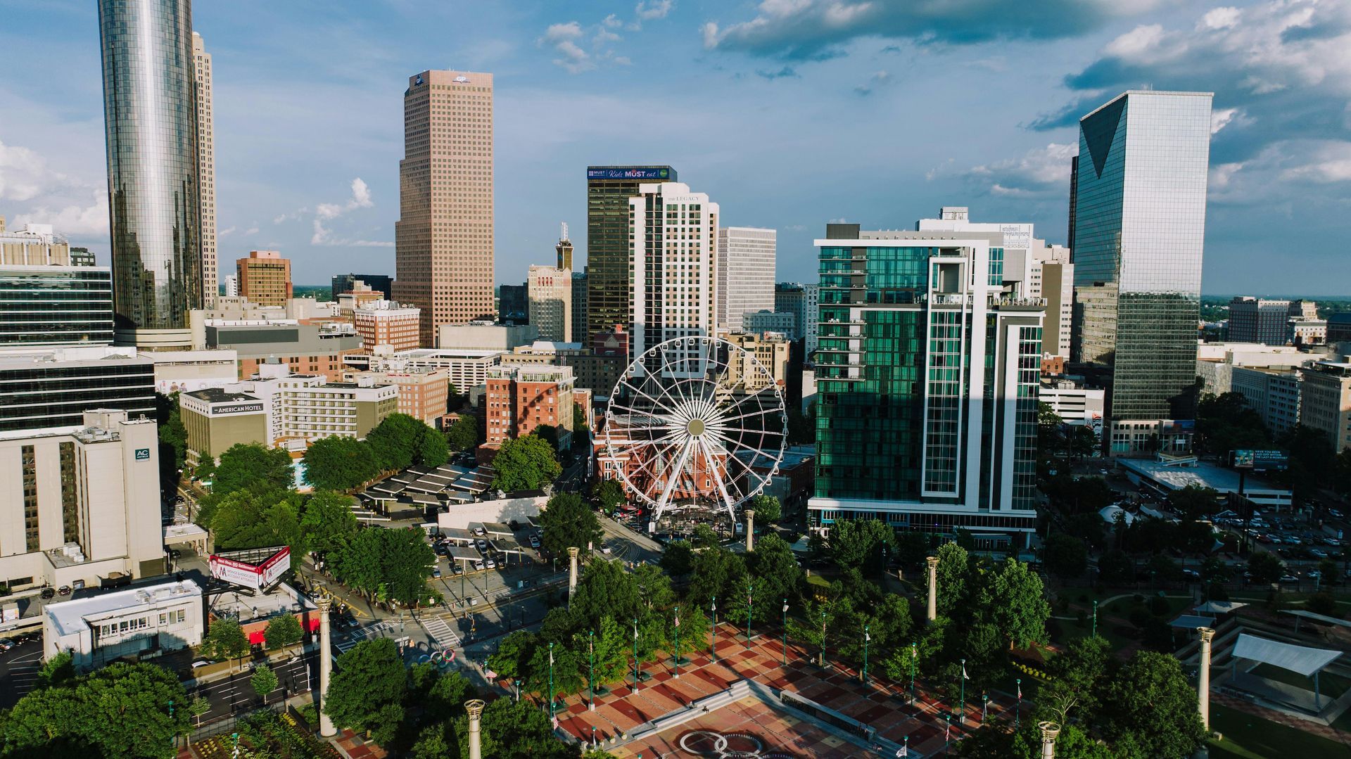 Greensboro, North Carolina skyline at dusk featuring the iconic Lincoln Financial building and lush city park greenery.