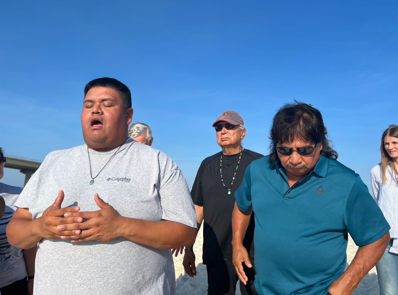 A group of men are standing in front of a blue sky