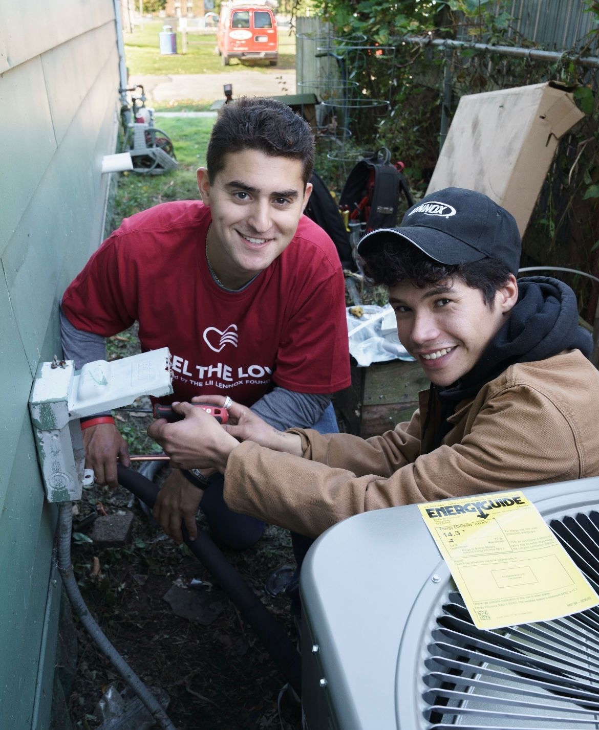 HVAC technician working on an outdoor AC unit; gauges and tools are visible.