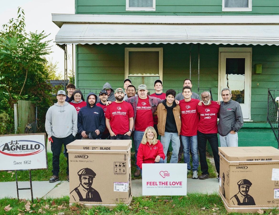 Three people seated at a table; woman shaking hands with another woman; man watches.