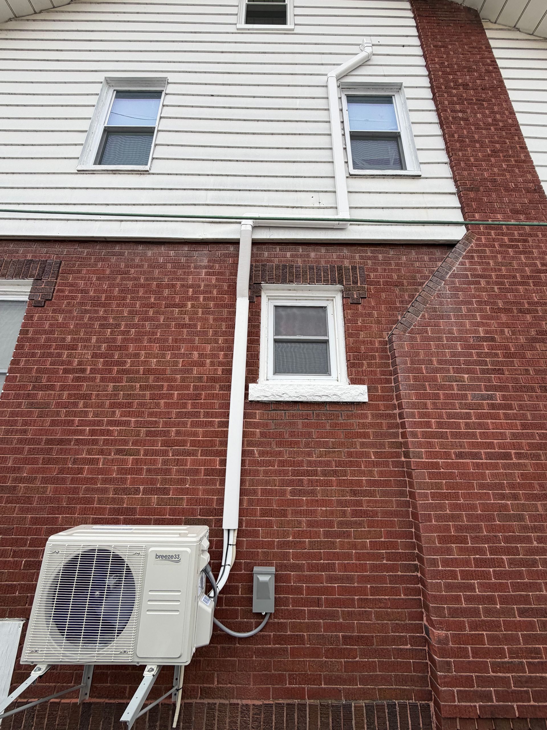 White wall with “Happiness is a journey not a destination” text. Above, a row of spotlights and an air conditioner.