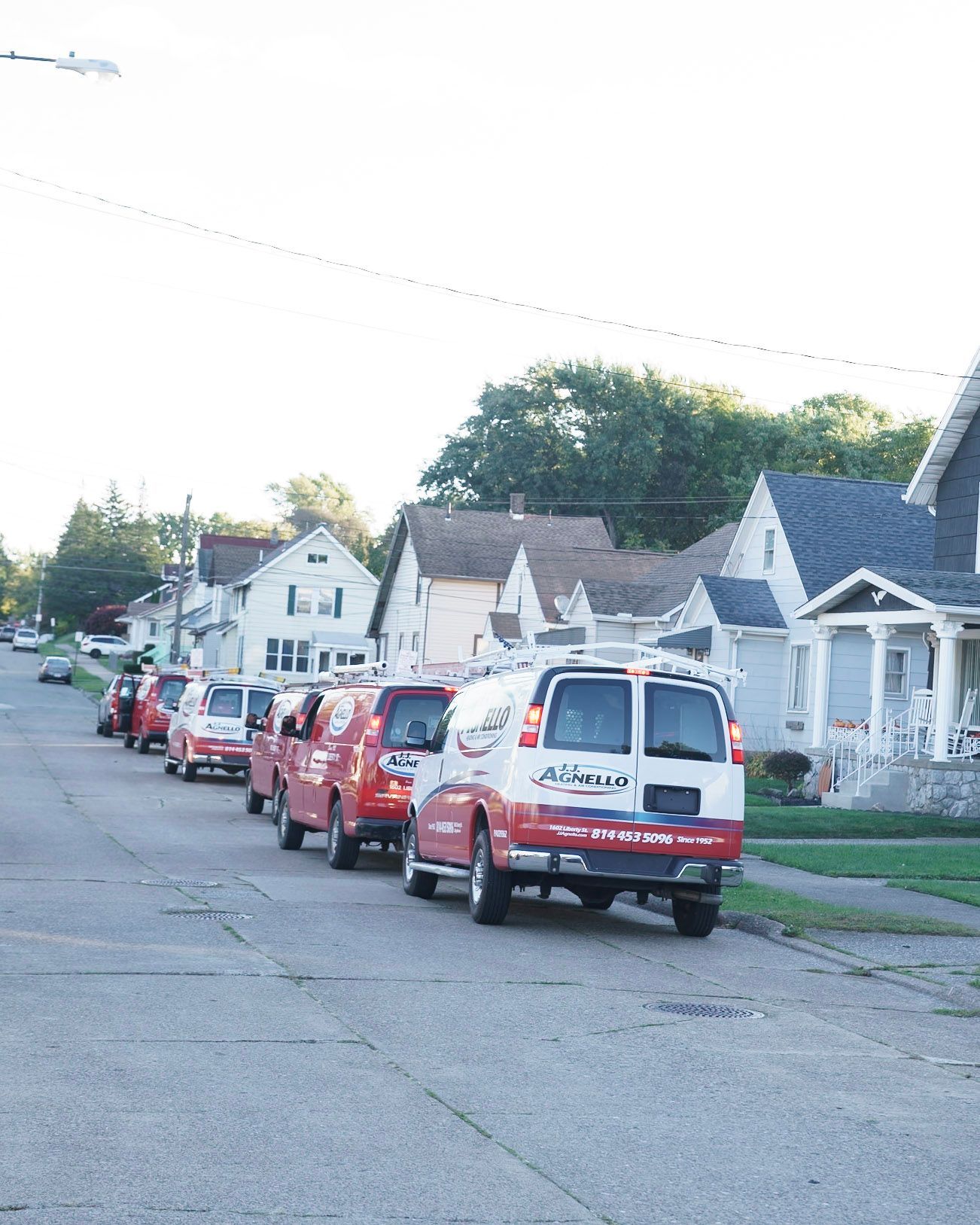 Cat resting on a white radiator against a white wall; fur is orange and white.