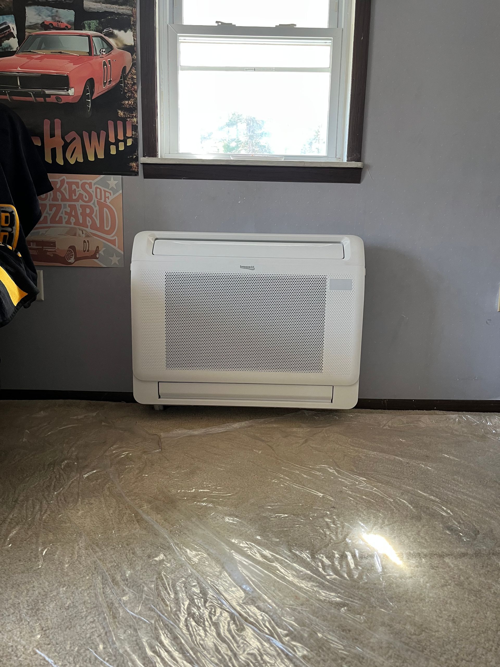 Man and child paint cardboard house in a closet; white paint, tan pants, wooden stool.