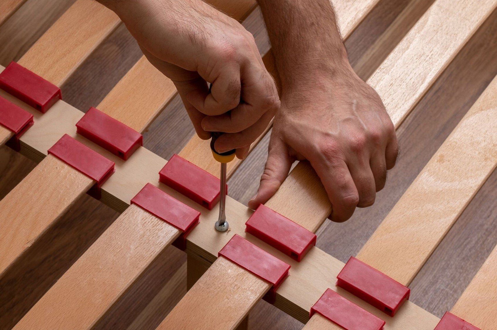 Bed slats being screwed down by handyman