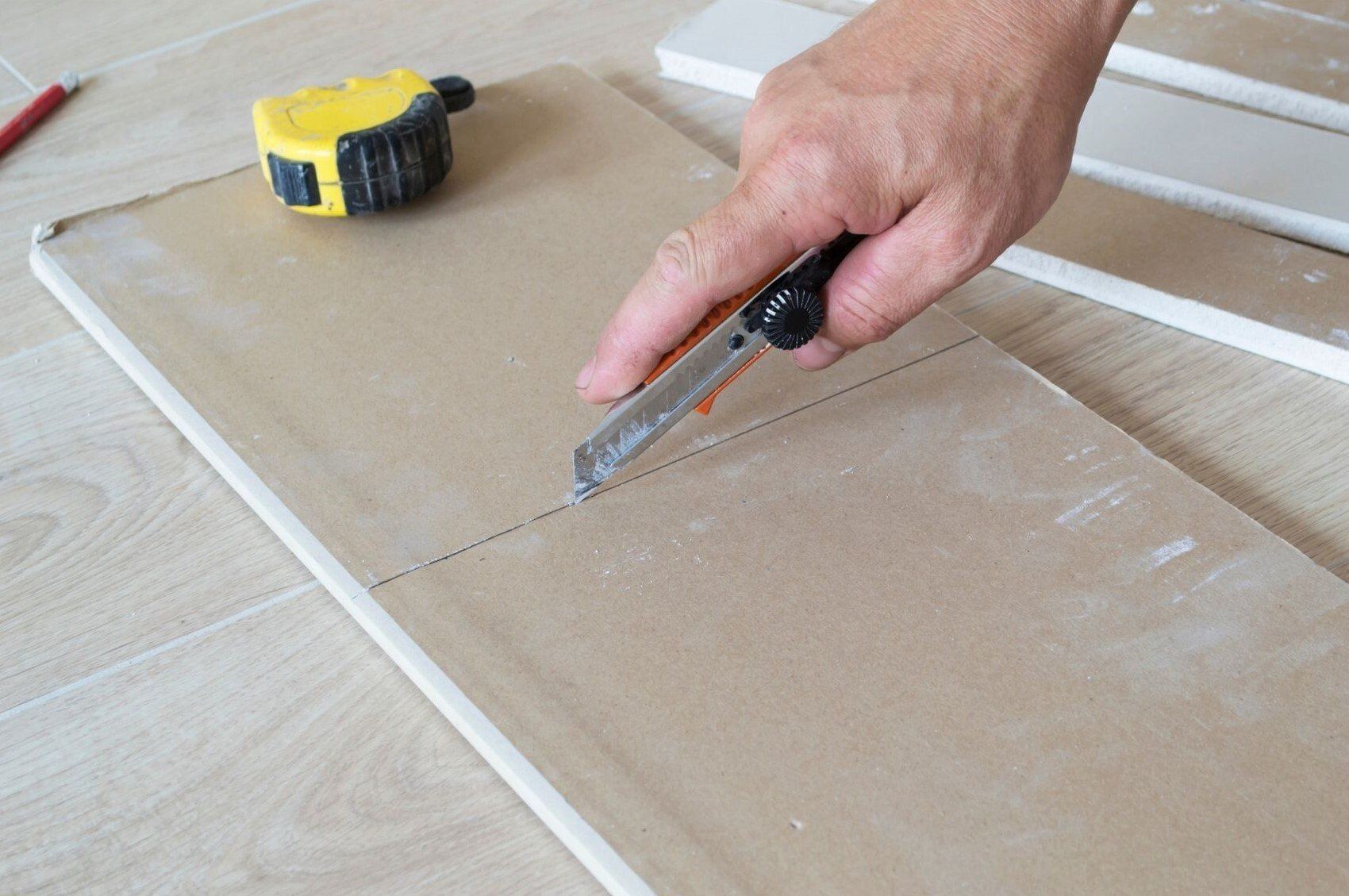 Bellingham Handyman cutting piece of drywall for repair