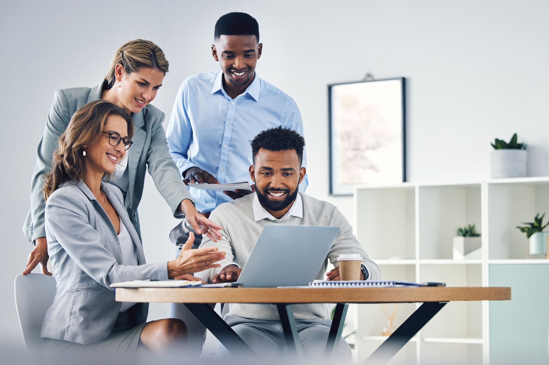A group of business people are looking at a laptop computer.