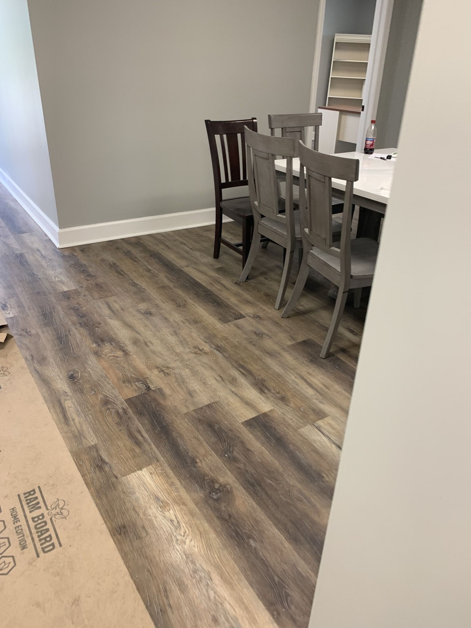 A dining room with hardwood floors and a table and chairs.
