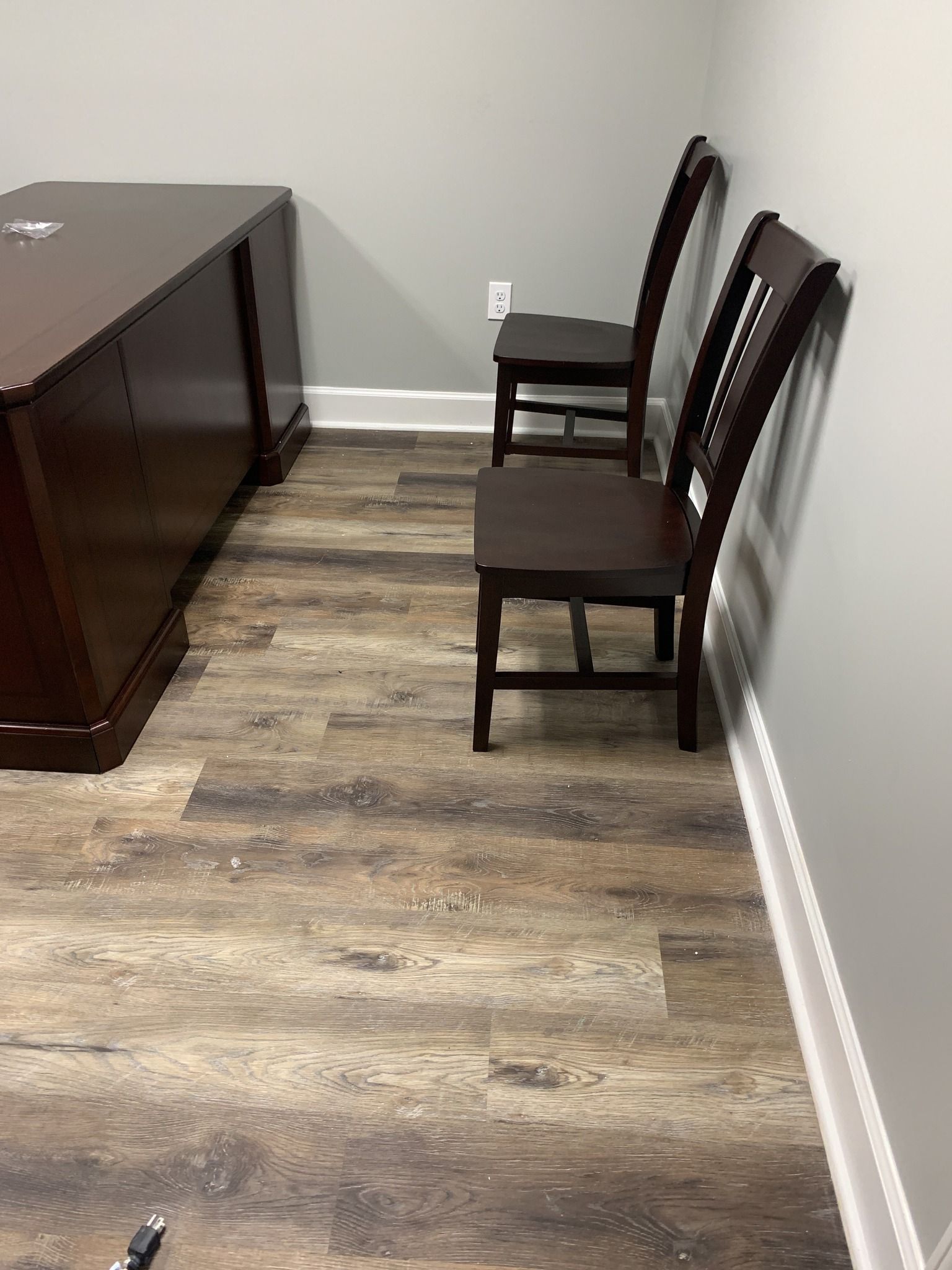 A room with wooden floors and chairs and a desk.