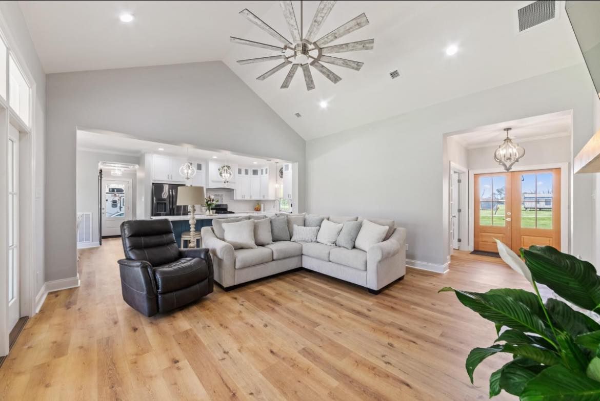 A living room with a couch , chair , and ceiling fan.