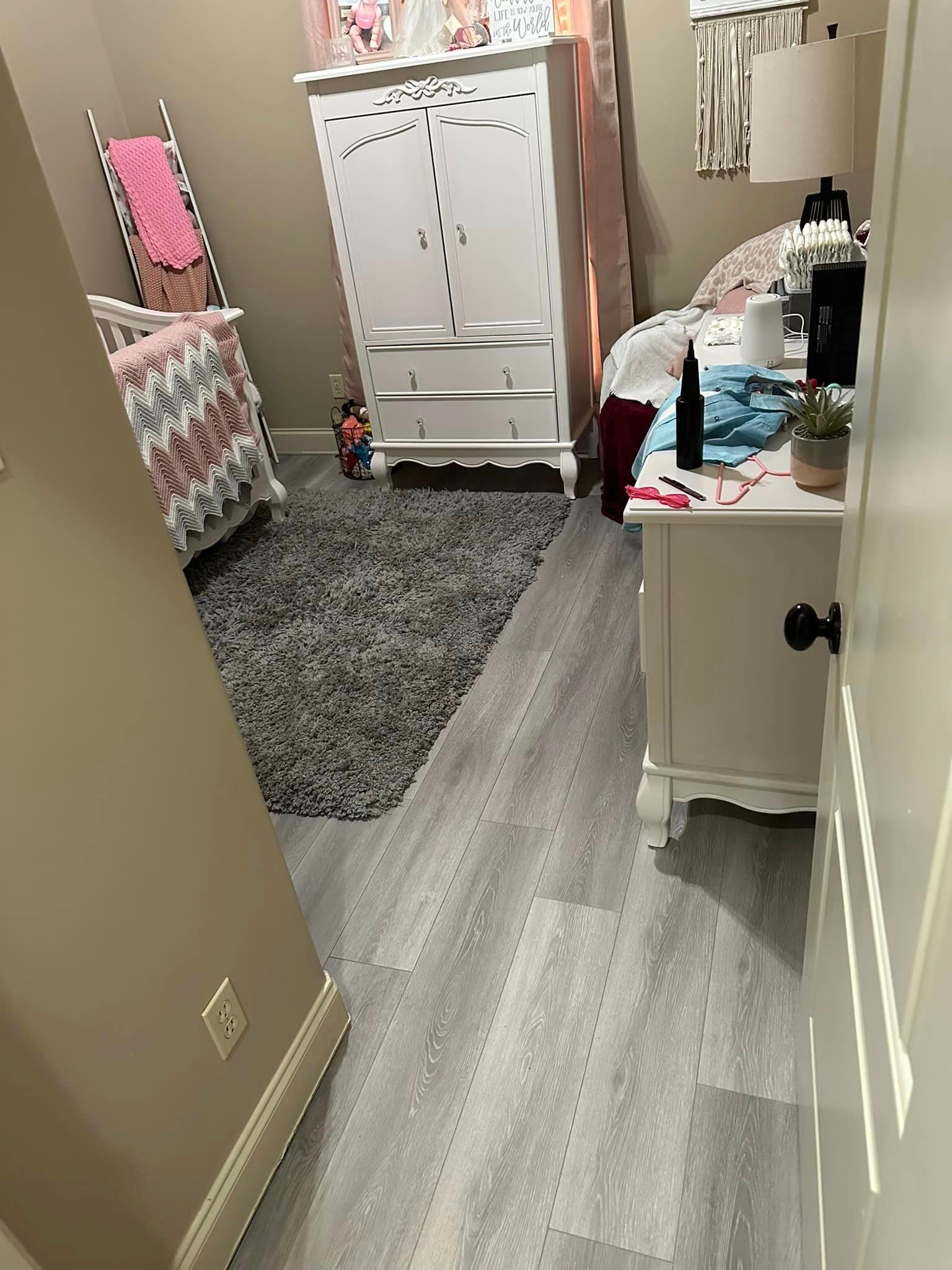 A bedroom with a bed , dresser , nightstand and rug.