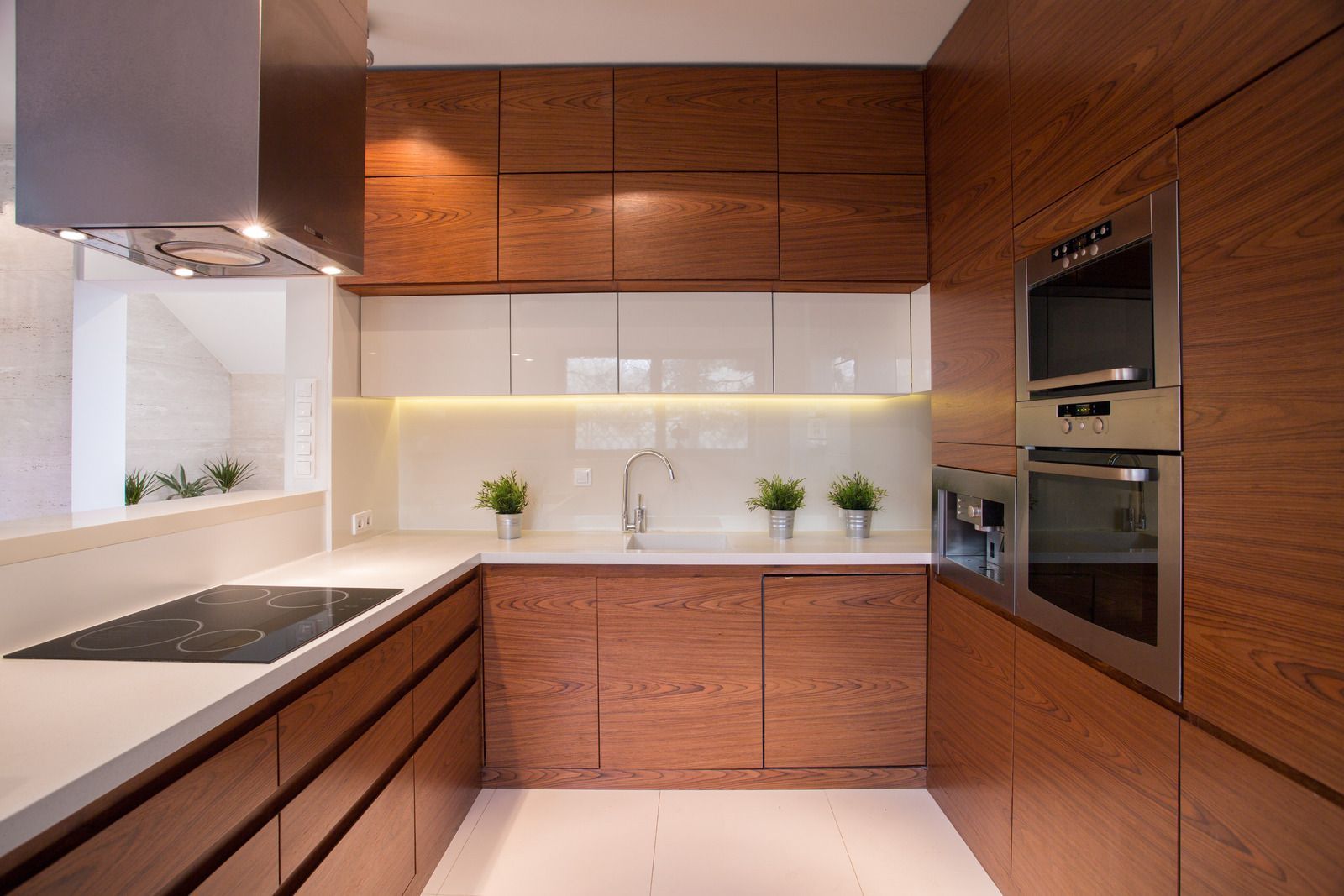 A kitchen with wooden cabinets , stainless steel appliances , and a stove top oven.