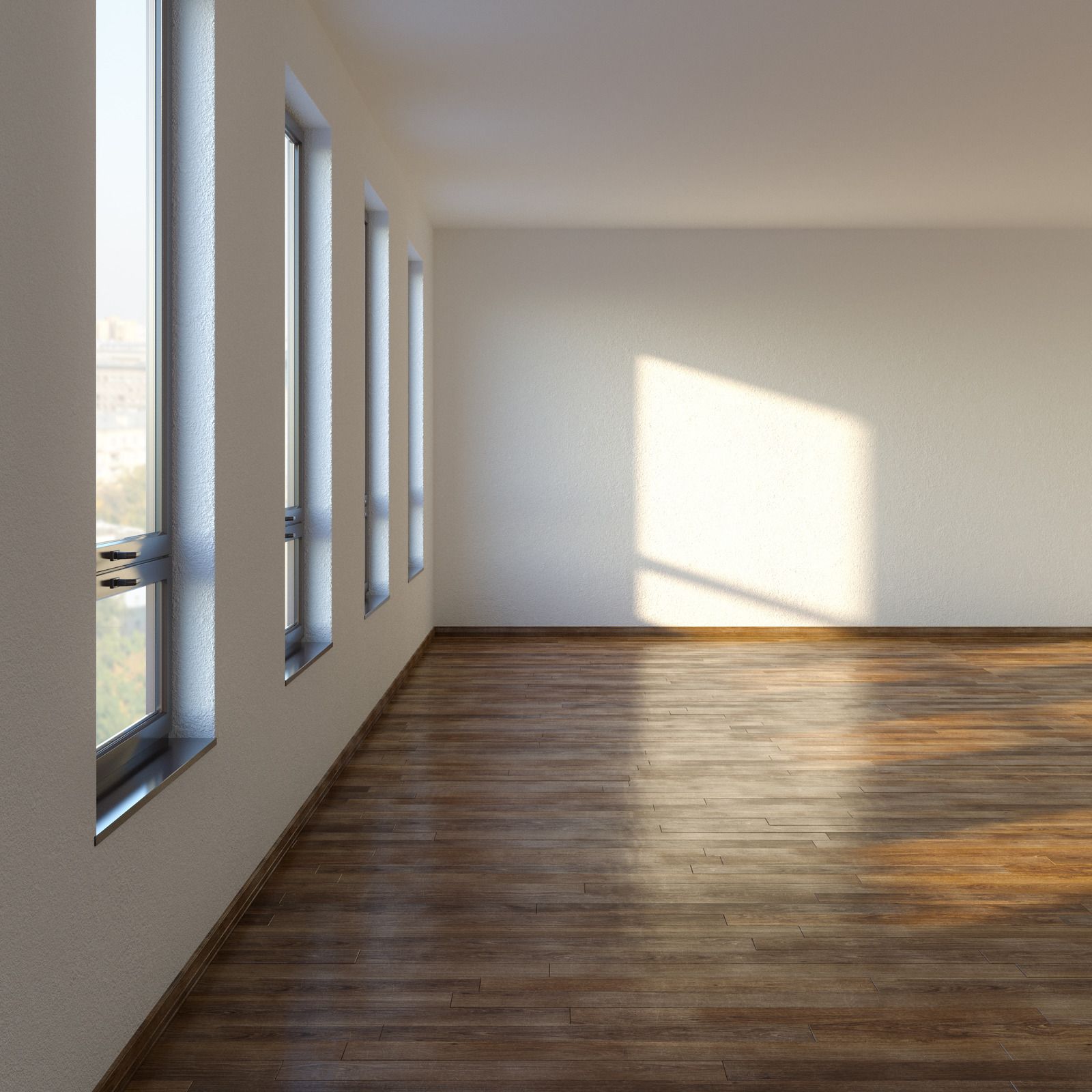 Empty room with wood floor, three windows, and sunlight streaming in.