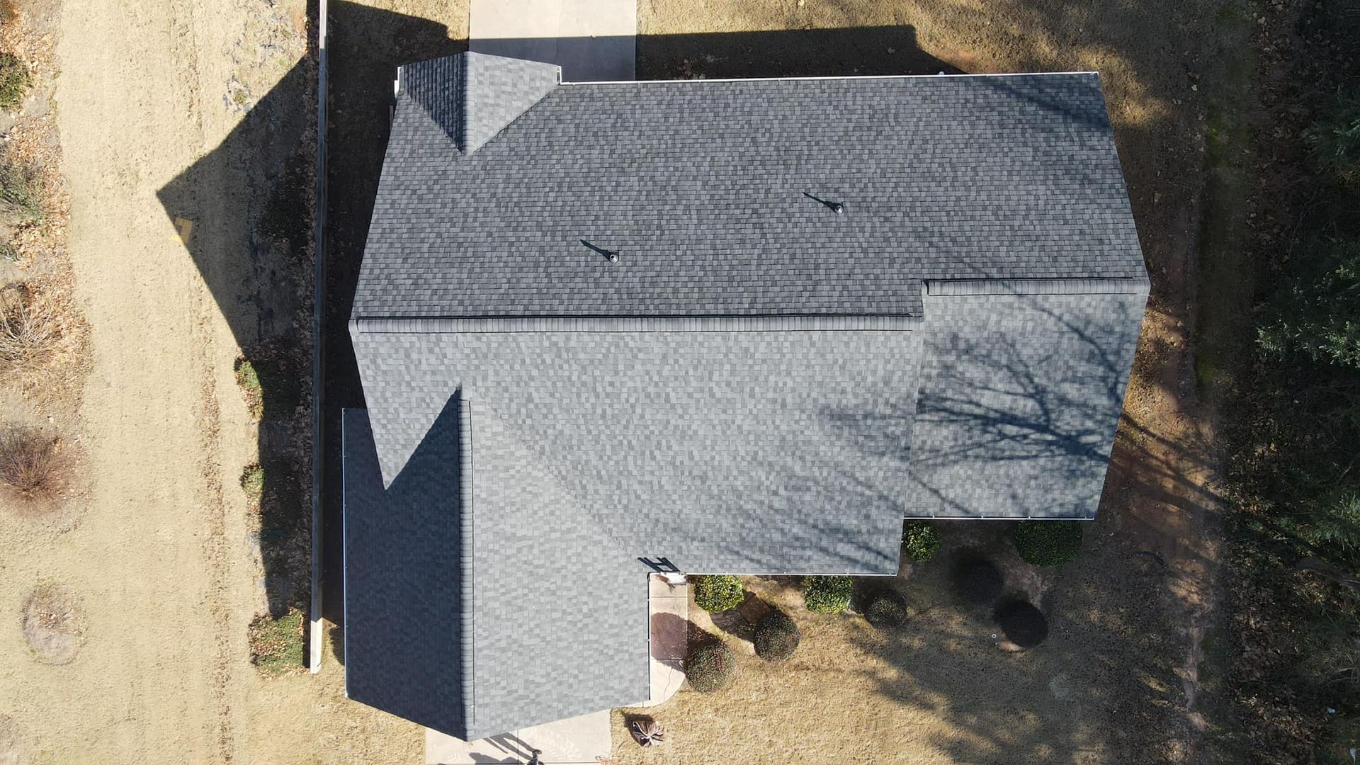An aerial view of a house with a roof and a driveway.
