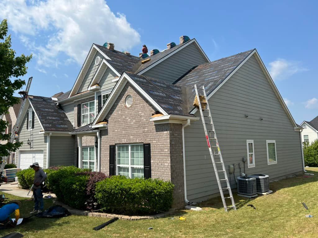 A roofer is working on the roof of a house.