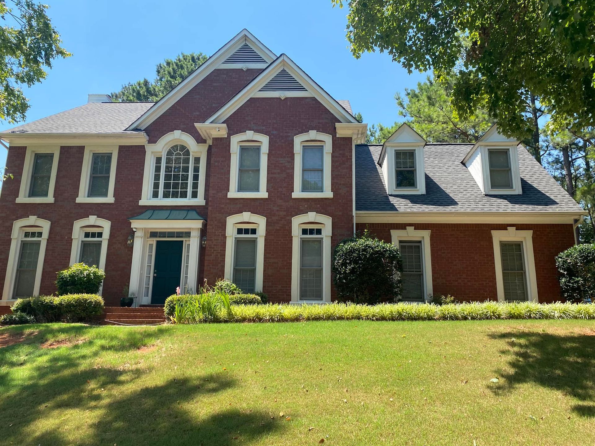 A large red brick house with a green door