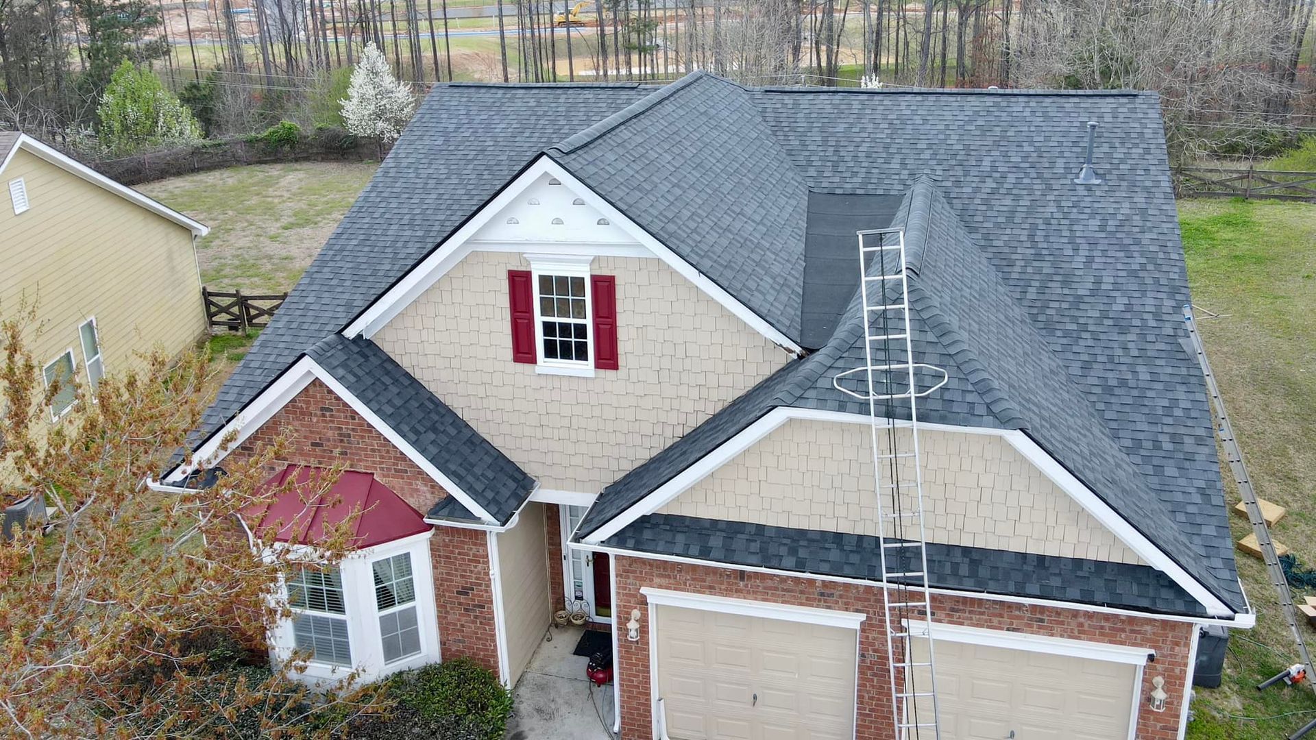 An aerial view of a house with a new roof being installed.