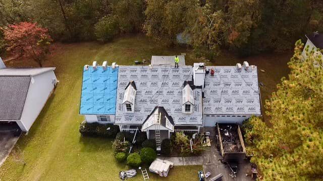 An aerial view of a house with a roof being installed.