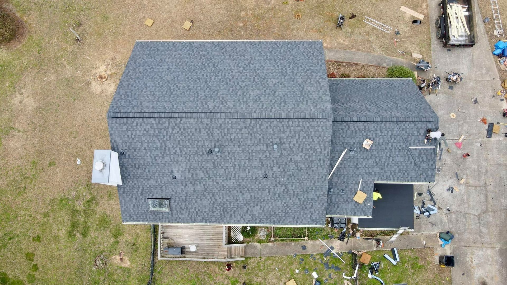 An aerial view of a house with a new roof being installed.