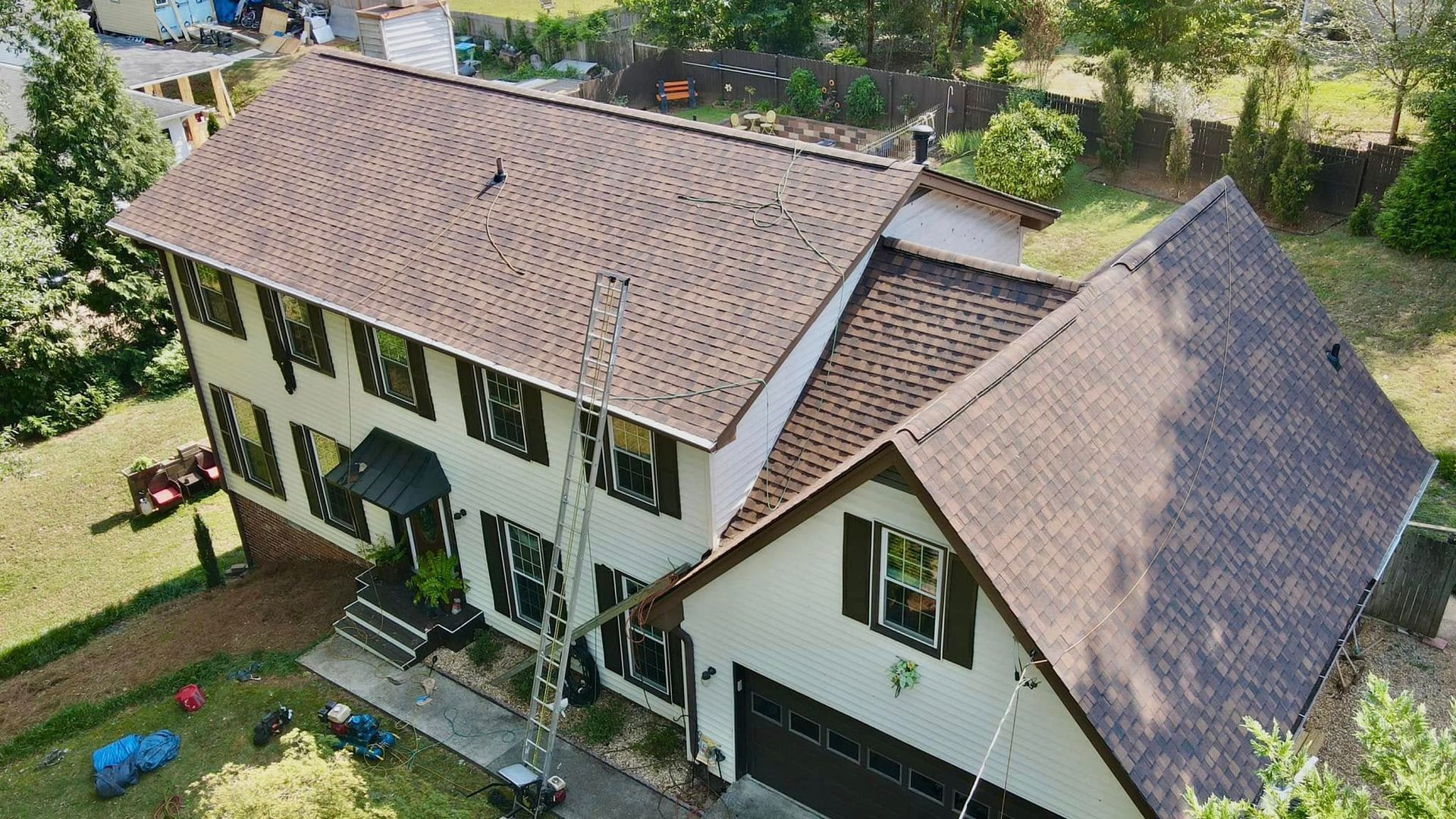 An aerial view of a large white house with a brown roof.
