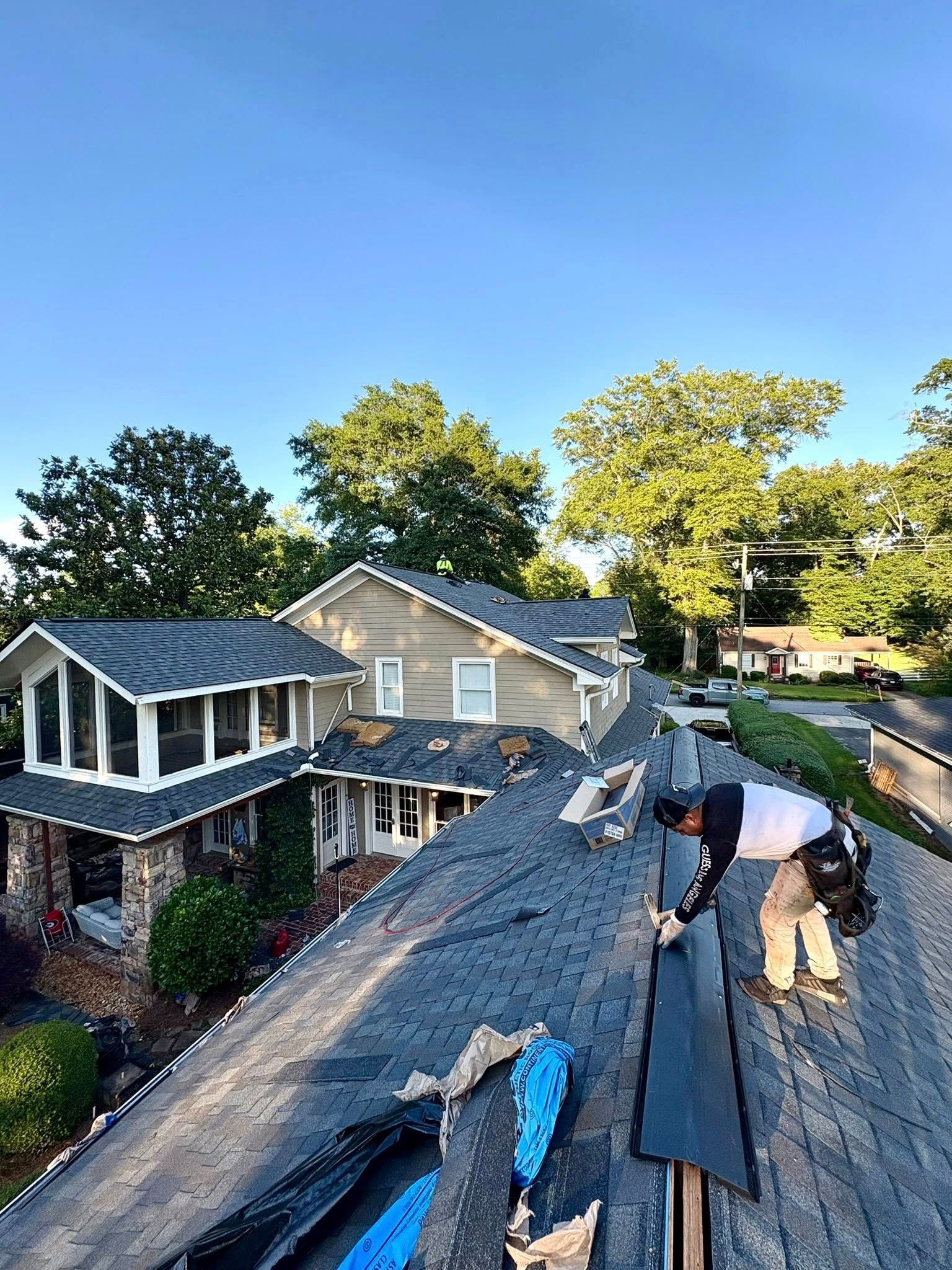 A man is working on the roof of a house.