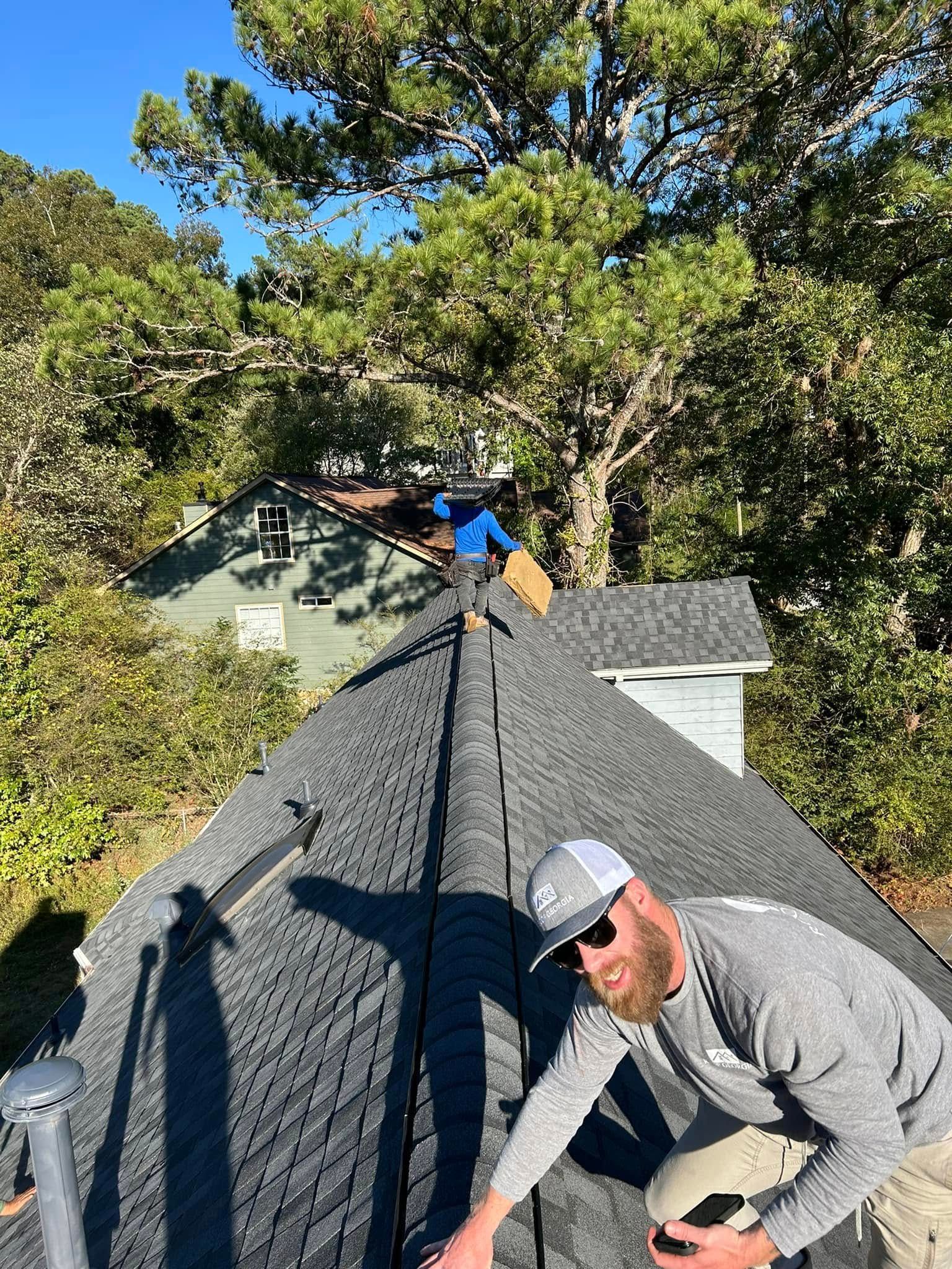 A man is working on the roof of a house.