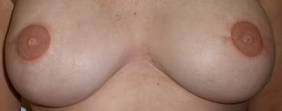 Close-up of a bare chest with pink nipples, cropped tightly against a plain background