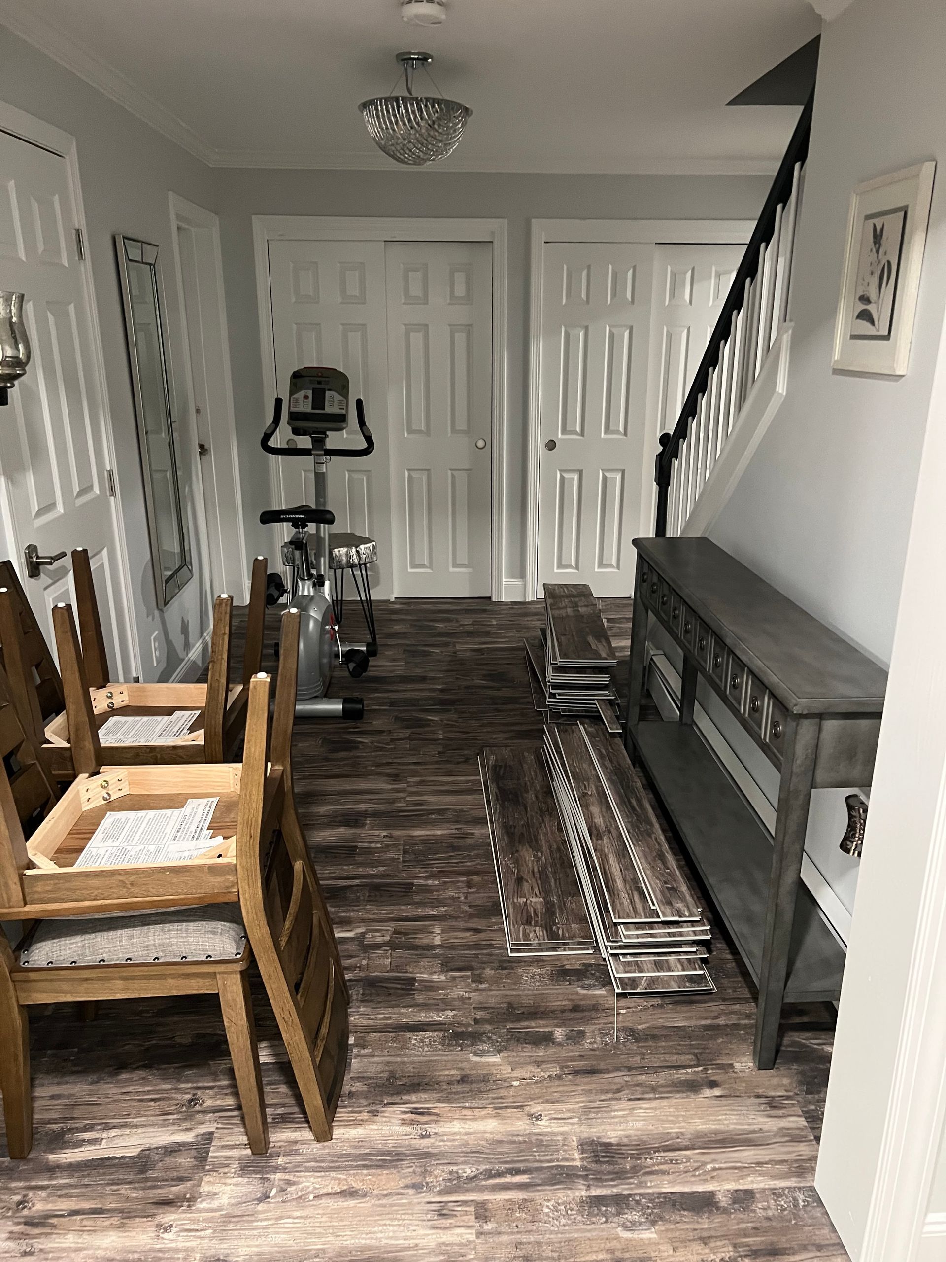A living room with a bicycle , chairs , and stairs.