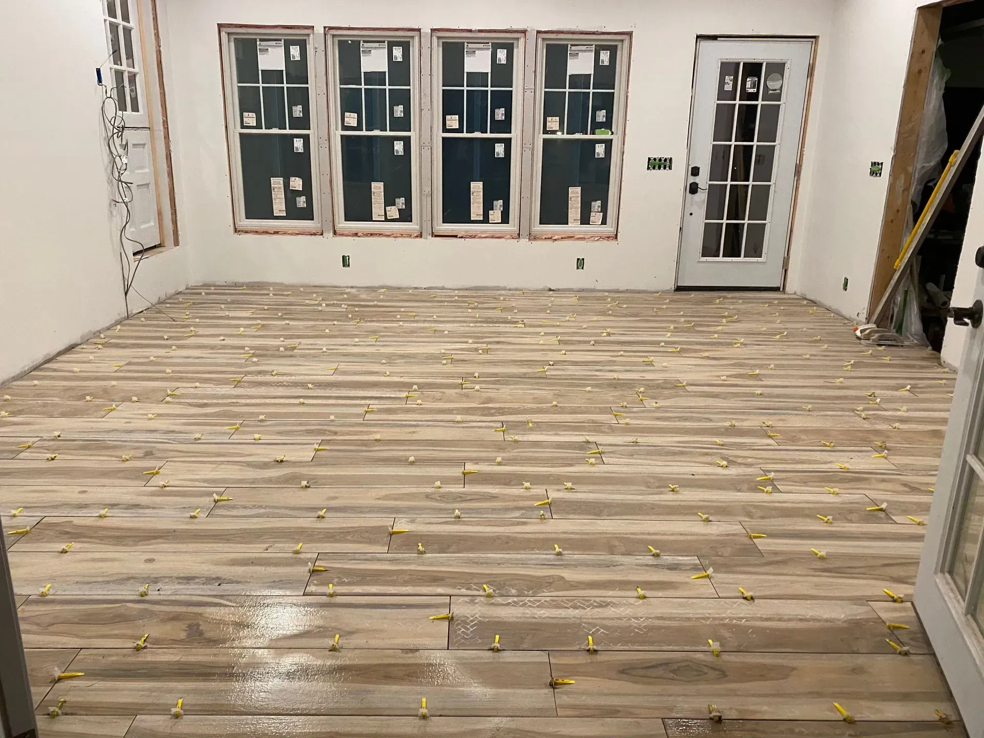 A large room with a wooden floor and a lot of windows.
