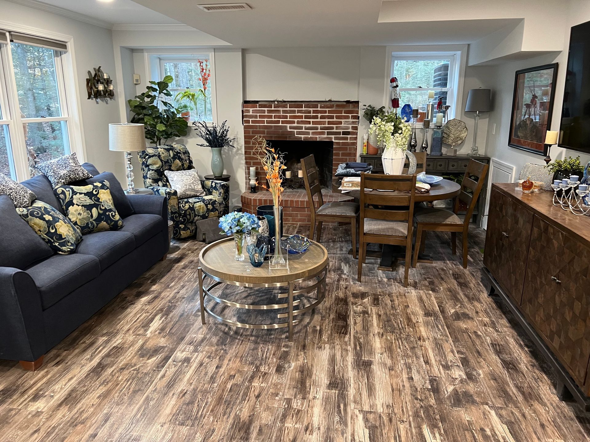 A living room with a couch , table , chairs and a fireplace.