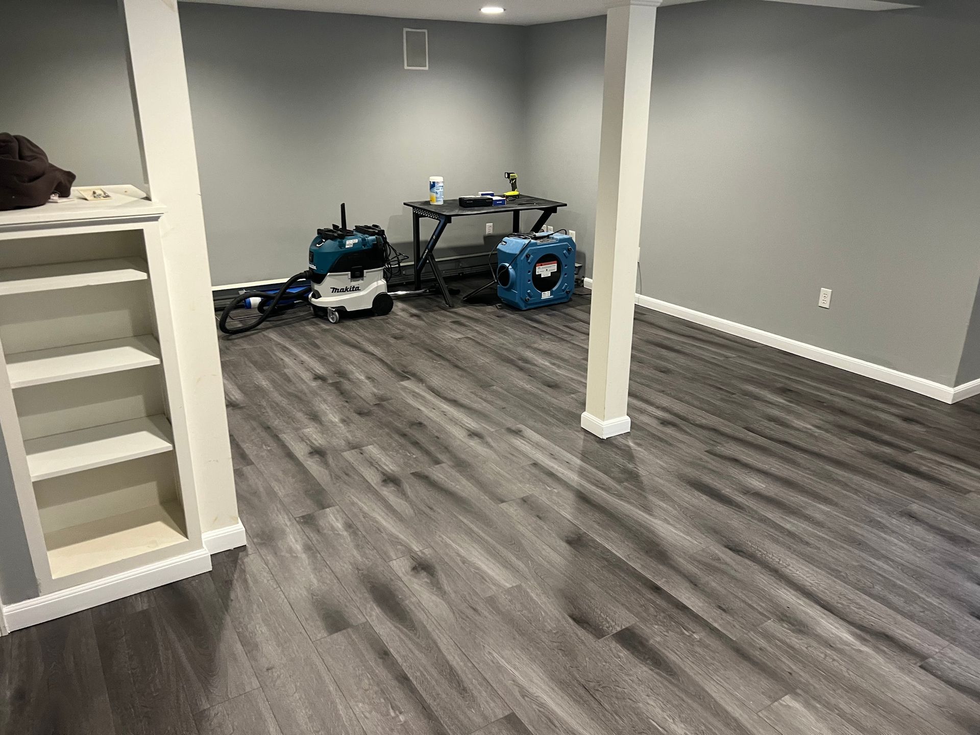 A basement with a wooden floor and a table.