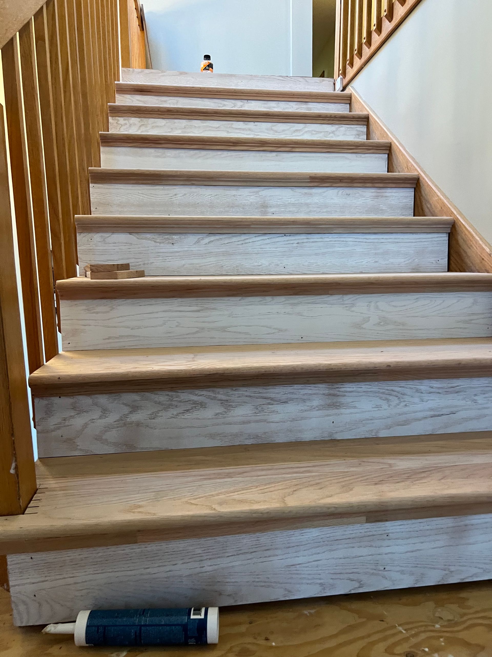 A staircase with a bottle of glue next to it.