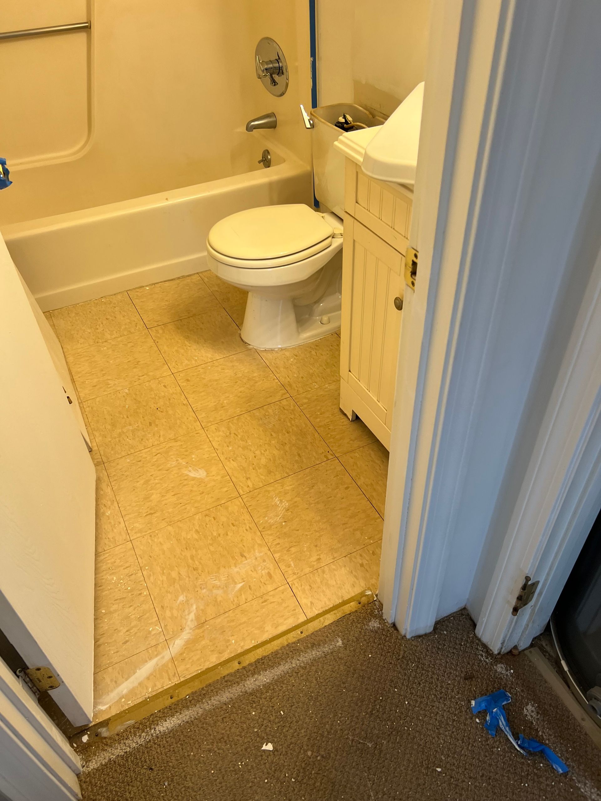 A bathroom with a toilet , sink and bathtub.