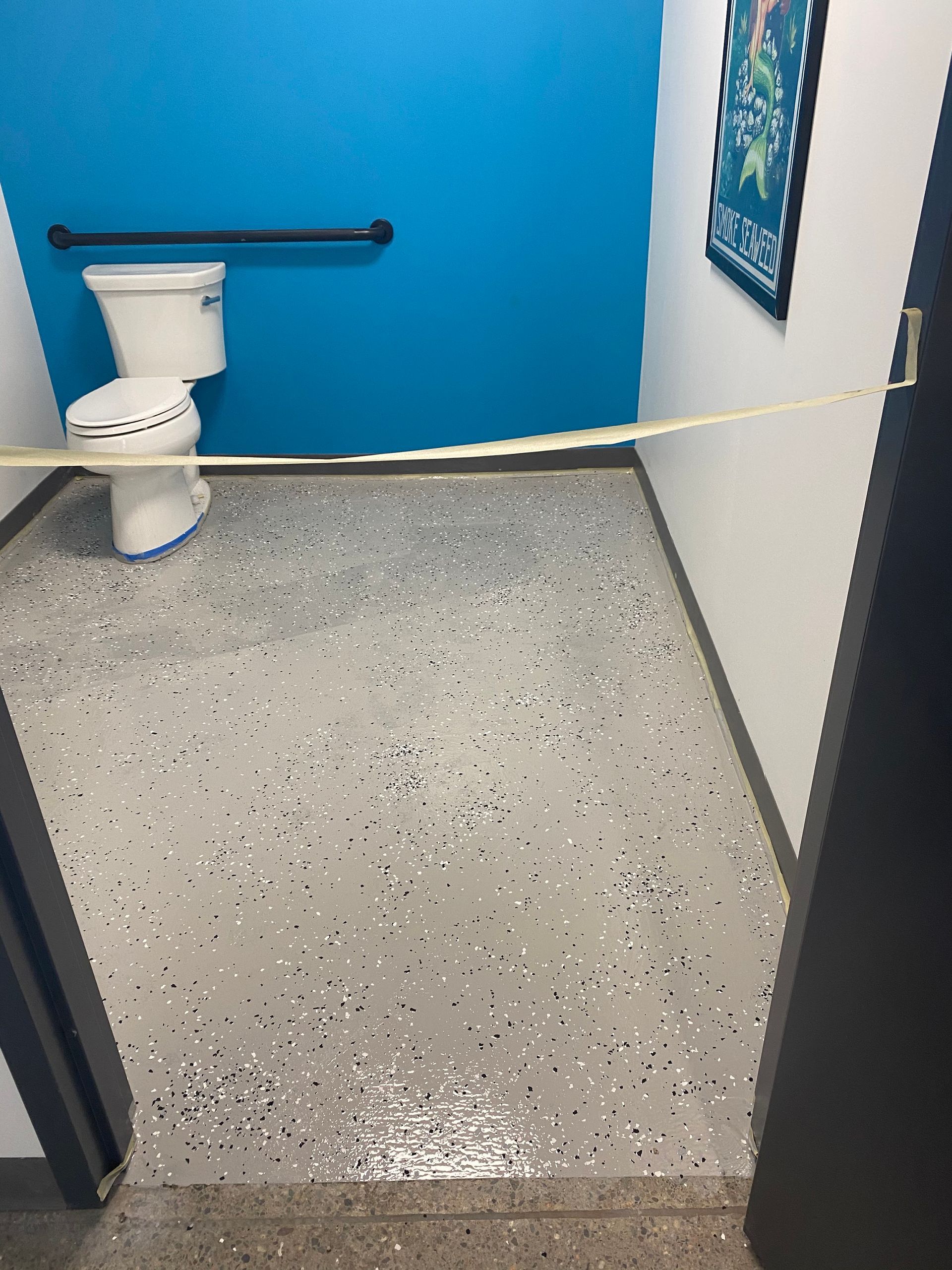 A bathroom with a toilet and a blue wall