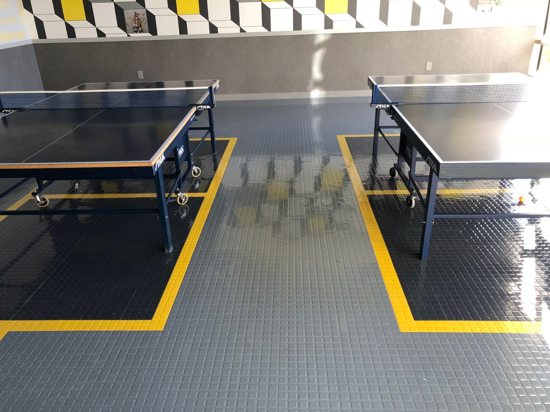 Two ping pong tables are sitting next to each other in a room.