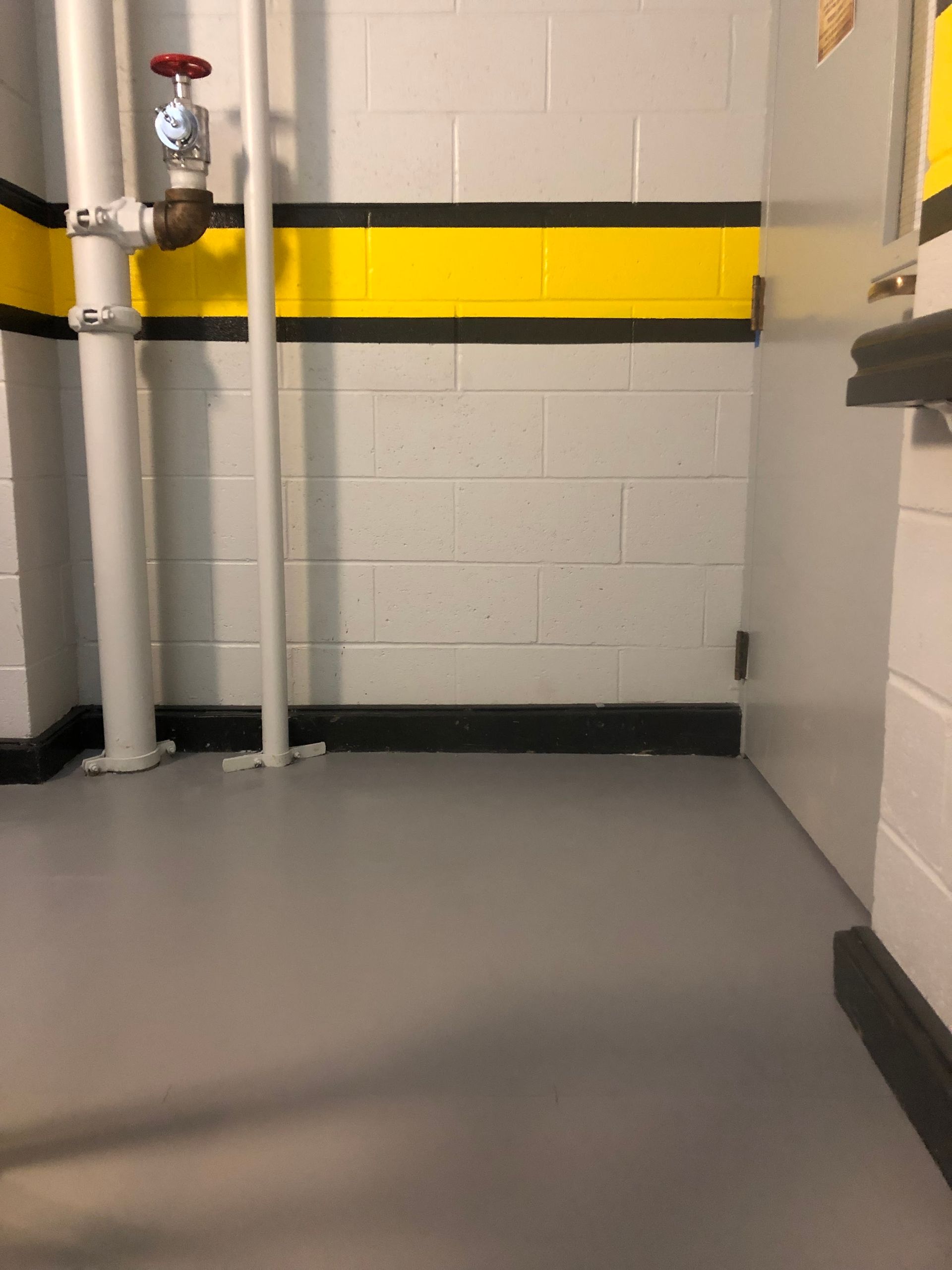 A room with a yellow and black stripe on the wall.