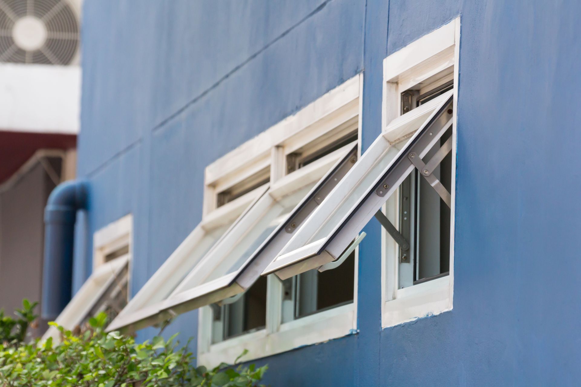 Blue Building With Several White-framed Awning Windows — Long Jetty Glass in The Entrance, NSW
