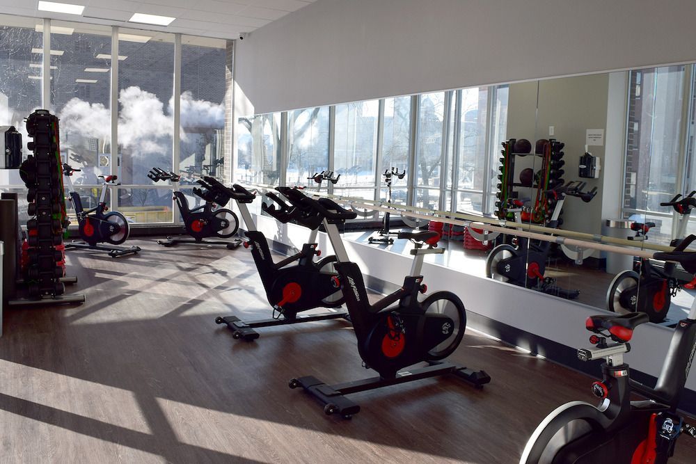A gym with a lot of exercise bikes and a large mirror at  Riley Towers, Indianapolis, IN. 