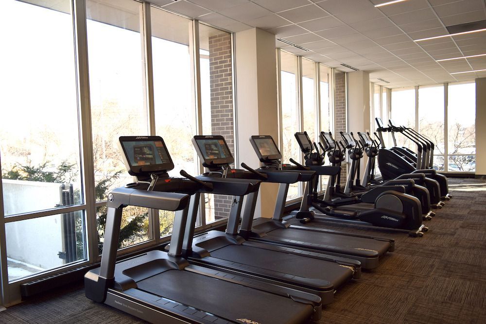 A row of treadmills and ellipticals in a gym at  Riley Towers, Indianapolis, IN. 