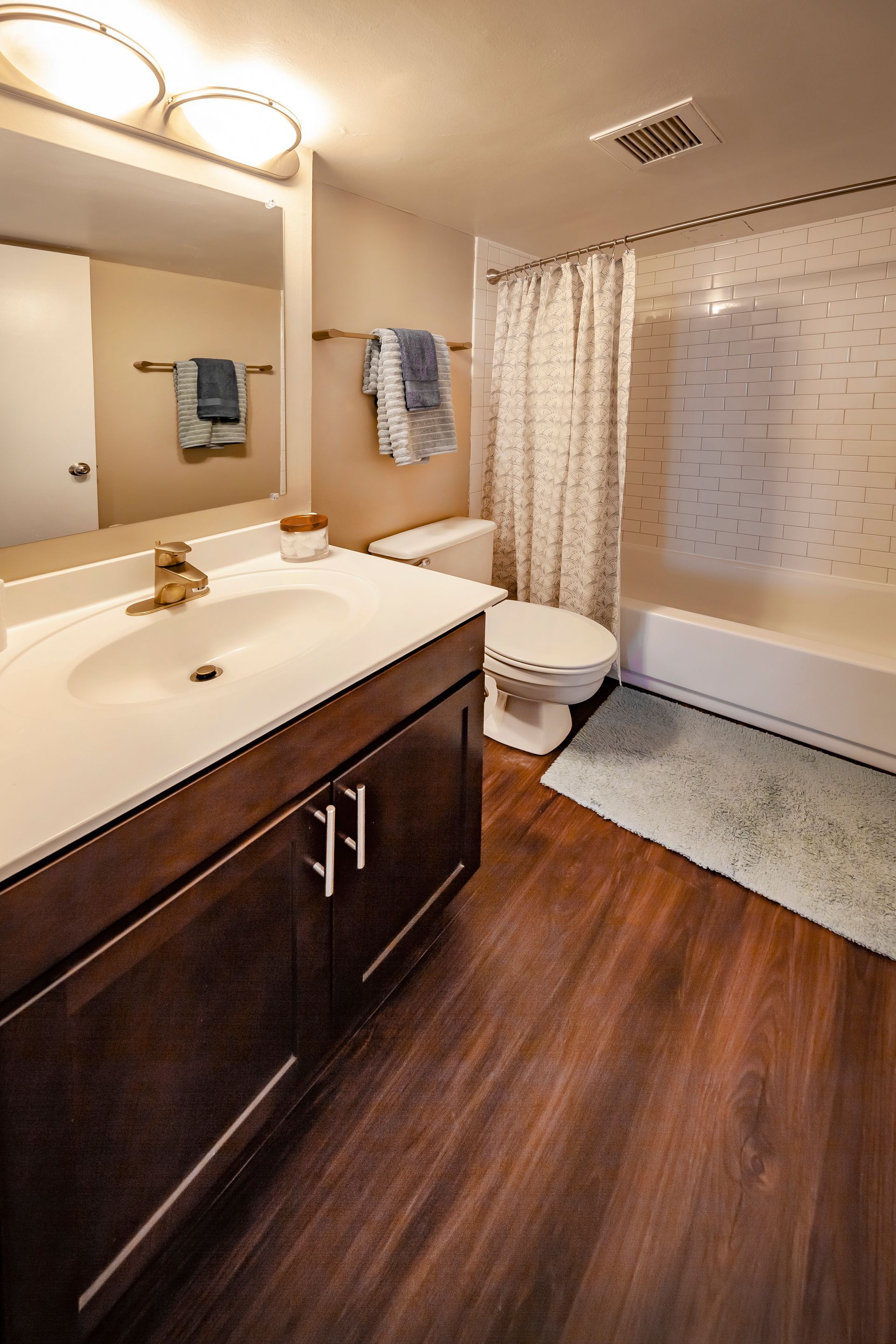 A bathroom with a sink , toilet , bathtub and mirror at  Riley Towers, Indianapolis, IN. 