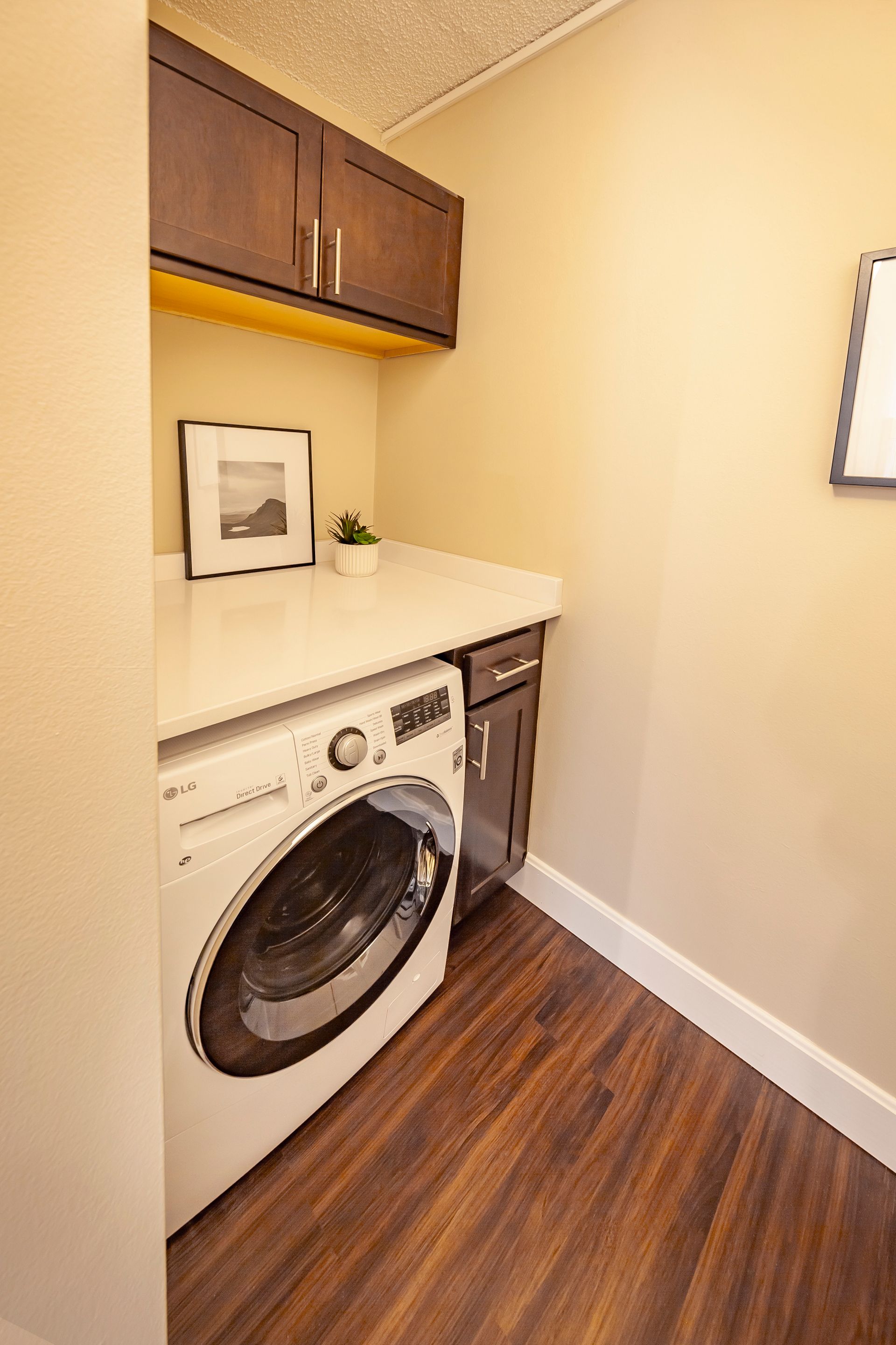 A laundry room with a washer and dryer and wooden floors at  Riley Towers, Indianapolis, IN. 