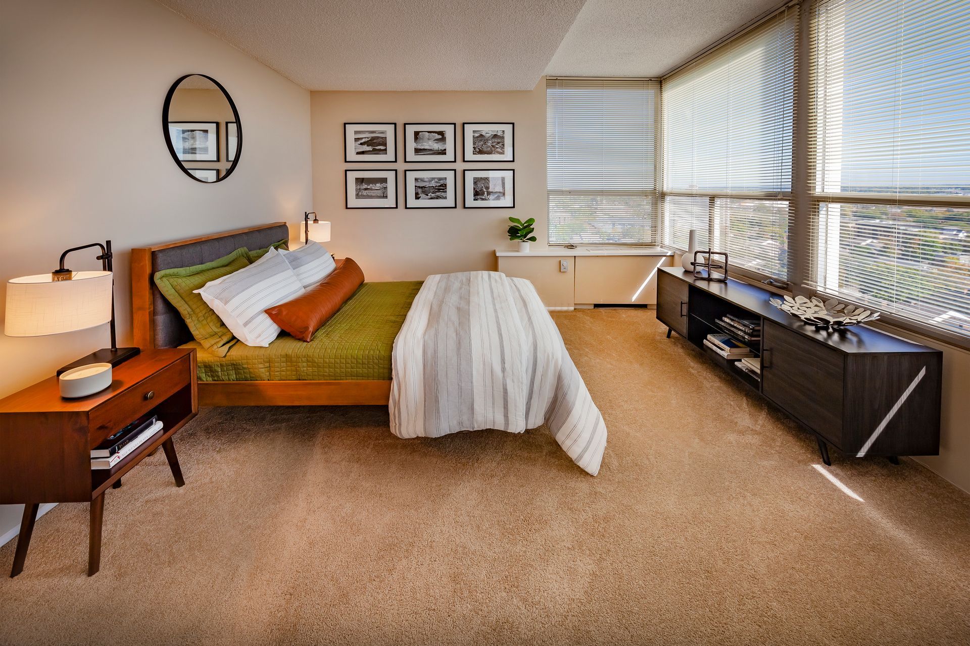 A bedroom with a bed , nightstand , mirror and dresser at  Riley Towers, Indianapolis, IN. 