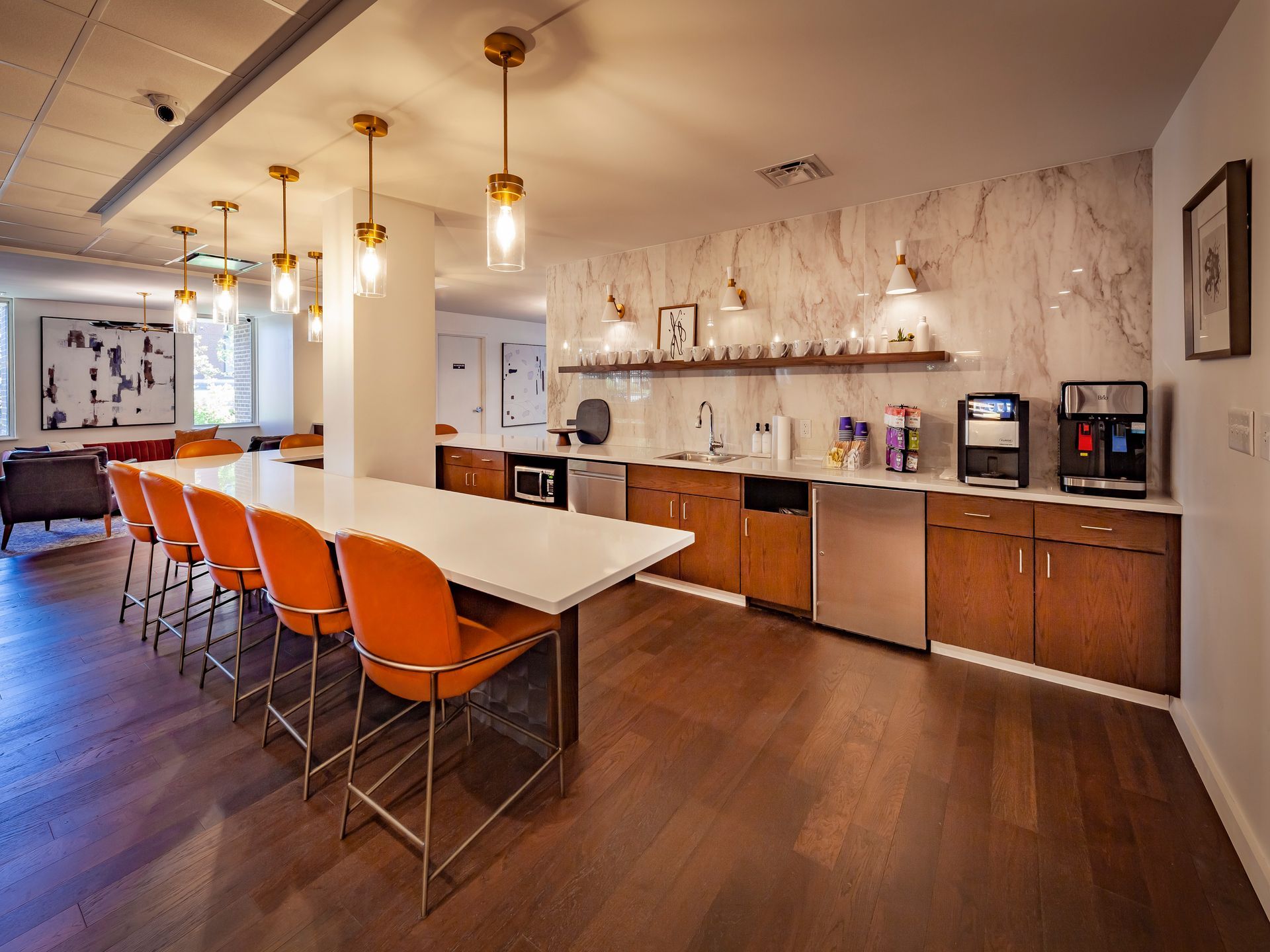 A kitchen with a long table and chairs and a coffee machine at  Riley Towers, Indianapolis, IN. 