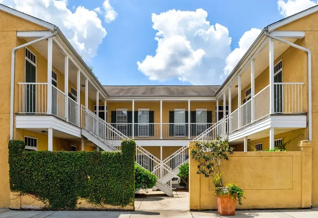 a yellow apartment building with stairs leading up to the second floor