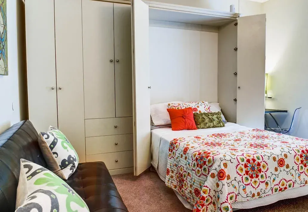 a bedroom with a bed , couch , and wardrobe .