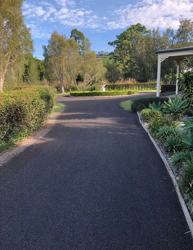 A Driveway Leading to a House Surrounded by Trees and Bushes — North Coast Asphalts in Dorrigo, NSW