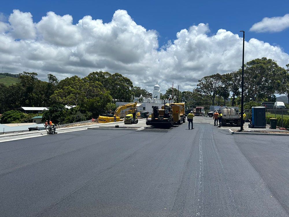 A Group of Construction Workers Are Working on a Road — North Coast Asphalts in Corindi Beach, NSW 
